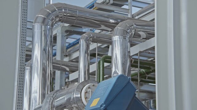 Close up of shiny clean pipe with elbow, branch and valve. Pipe flange joint