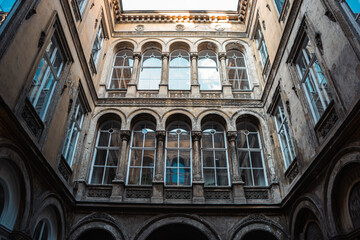 Upward view of an old European courtyard with arched windows and classical architecture in Budapest, Hungary