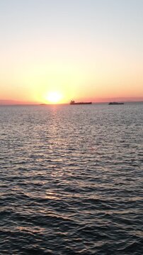 Maritime transportation during golden hour sunrise. Ocean shipping industry with warm evening ligh