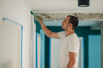 Painter painting a wall with green paint in a building