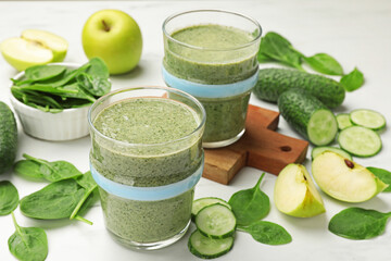 Tasty smoothie and spinach leaves on white marble table, closeup