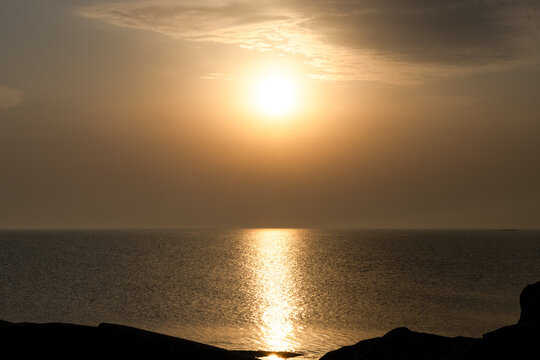 Sunset over open sea with golden reflections on the water. A calm, minimalist ocean scene with soft colors and a peaceful mood.