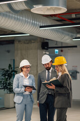 Engineers consulting on building plans in industrial setting