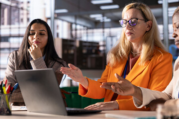 Successful women leaders discuss business strategies in a financial district office, promoting...