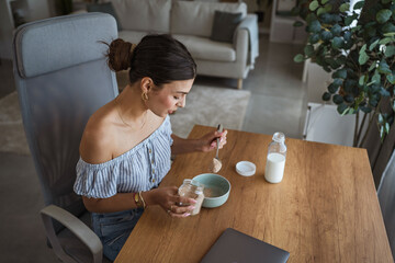 adult woman sit at table in the living room making healthy breakfast