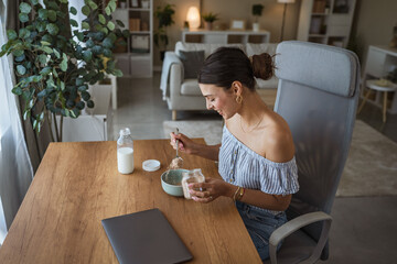 adult woman sit at table in the living room making healthy breakfast