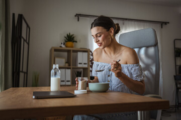 adult woman sit at table in the living room making healthy breakfast