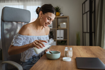 adult woman sit at table in the living room making healthy breakfast