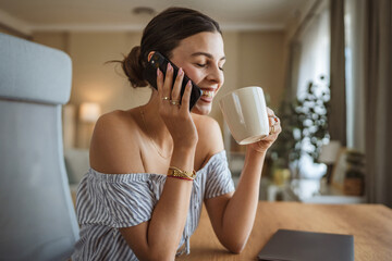 happy woman enjoy while drink coffee and talk on mobile phone at home