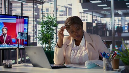Stressed black business leader working in discomfort with a headache, feeling overburdened and...