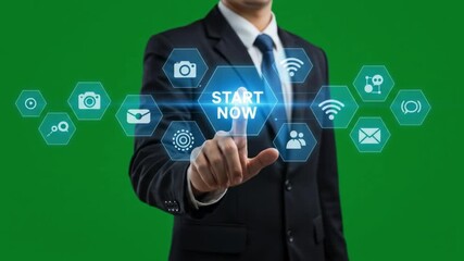 Man in suit pointing at start now button surrounded by icons on a digital interface on green screen - Powered by Adobe