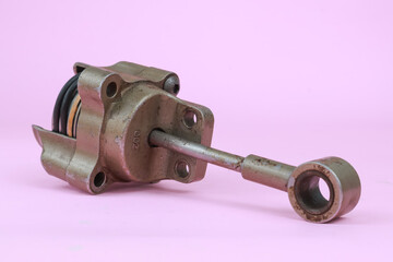 Turbocharger Actuator also known as a wastegate actuator with body cover partialy split and showing the inside part. isolated on pink background.
