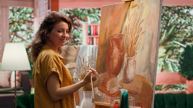 Artist uses talent and tie dye to create a masterpiece on canvas in creative workshop, blending colors with paintbrush. Bringing a rustic artwork to life with a special painting technique. Camera A.