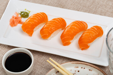 Sake nigiri sushi with salmon served on platter with soy sauce