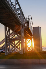 Industrial bridge infrastructure with dramatic sunset lighting. Heavy industrial infrastructure at spectacular sunset