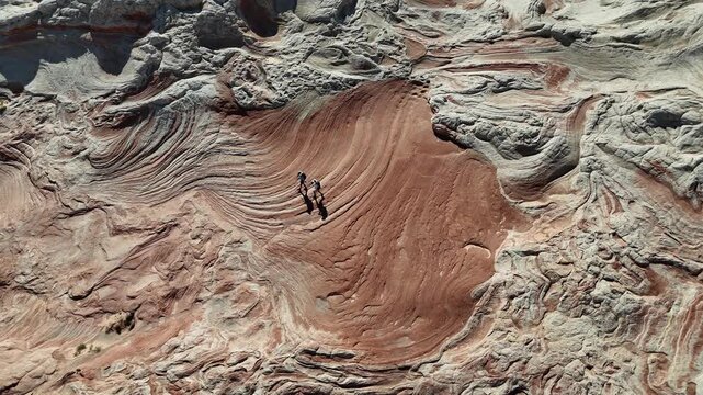 Drone view of hikers on amazing White Pocket red and white sculpted red sandstone waves