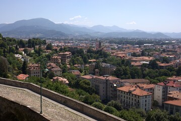 Naklejka premium Panoramic hillside view of The Venetian Walls, Bergamo with green rooftops and summer landscape, Italy