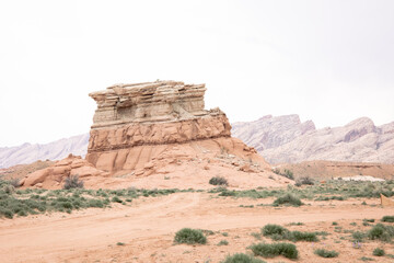 Striking red rock formations rise from the arid desert floor, creating a bold and rugged landscape...