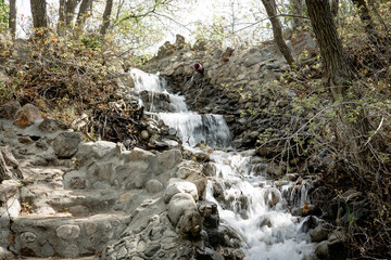 A gentle stream flows smoothly over weathered rocks, creating a tranquil scene filled with the...