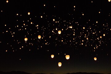 Soft, glowing lights drift through the darkness, creating a magical contrast against the deep night...