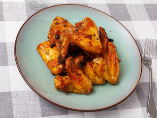 Dish of delicious baked chicken wings. Close-up image
