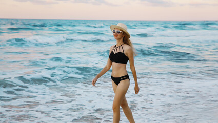 Summer vacation, happy slim woman walking running on sea beach, coast with waves