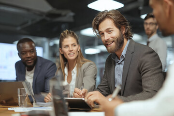 A business group of people are sitting at a table, one of them is writing something in a notebook. atmosphere seems to be businesslike and focused
