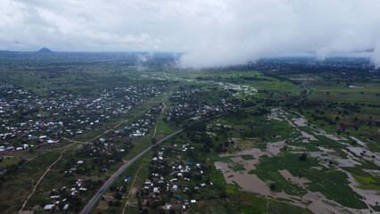 Aerial view of a rural landscape with a town and a mountain under a cloudy sky in daytime setting tanzania