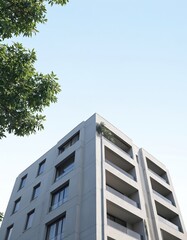Modern apartment building with clean lines against clear blue sky. Features balconies, multiple floors, ideal for residential living commercial use. Green foliage from nearby trees adds natural touch.