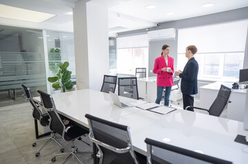 Colleagues sit drinking coffee and talking during a break at work. 