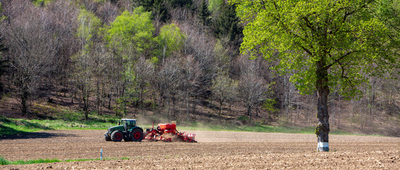 farmer harrows land near clervaux in luxemburg