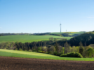 countryside landscape in luxemburg with wind turbine under blue sky in spring