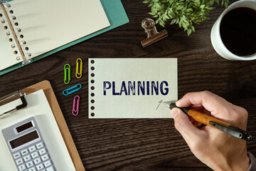 There is a piece of paper with the word Planning. It is as an eye-catching image.
