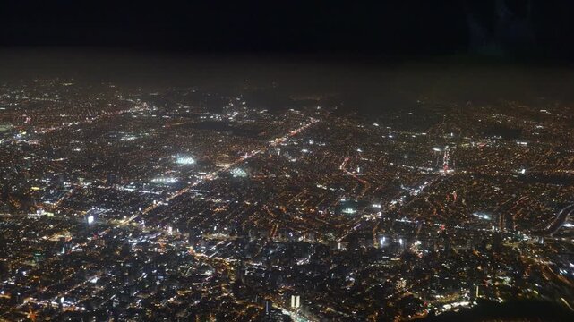 Night city view from airplane. Urban lights, illuminated streets, aerial perspective, skyline, buildings, travel, aviation, high altitude, cityscape, glowing grid. City of Lima from the aerial view