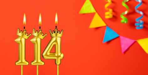 Number 114 birthday candle on an orange background with pennants