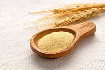 Wheat semolina in a wooden spoon - Triticum