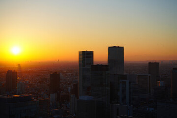 Fototapeta premium Golden Hour Sunset over Tokyo Skyline: Dramatic Silhouette of Modern Skyscrapers
