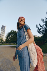 Lifestyle woman wearing modern boho-western denim street style outfit with a red bandana and...