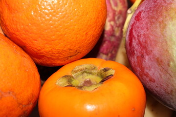Natural Food Assortment. Persimmon with Sweet Potato, Mango, and Orange. Persimmon with Selective Focus. Natural Produce Medley. Healthy and Vibrant Ingredients.