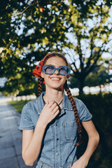 lifestyle woman wearing modern boho-western denim and oversized sunglasses smiles outdoors with...