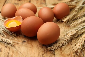 Fresh eggs and spikes on wooden table, closeup