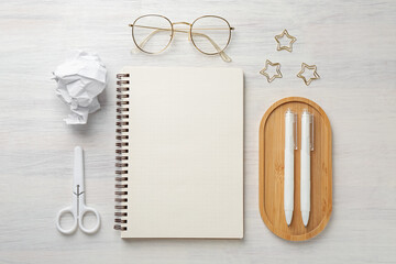 Flat lay composition with notebook on light wooden table