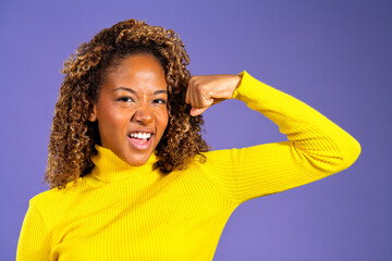 Young woman showing strength and empowerment on purple background