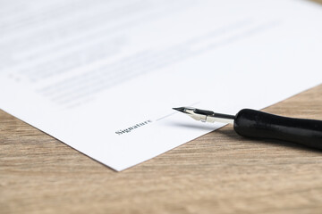 Notary document and fountain pen on wooden table, closeup