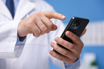 Doctor with smartphone in clinic, closeup. Online medical consultation