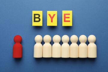 Dismissal. Red figure lying apart among wooden ones and word Bye made with cards on blue...