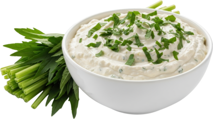 Creamy dip in white bowl garnished with chopped green herbs and fresh herb stems transparent background