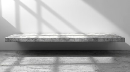 Minimalist concrete shelf against a white wall illuminated by soft window light