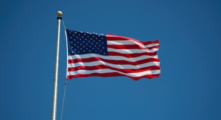 Fototapeta premium American flag waving in clear blue sky