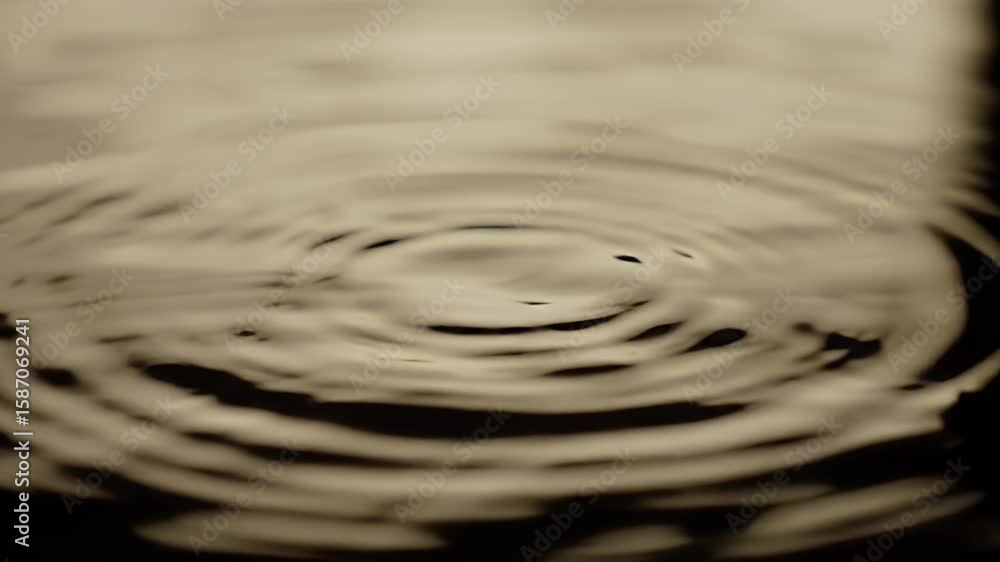 Poster water droplet impact forming circular ripples on a brown fluid surface creating an abstract and mini